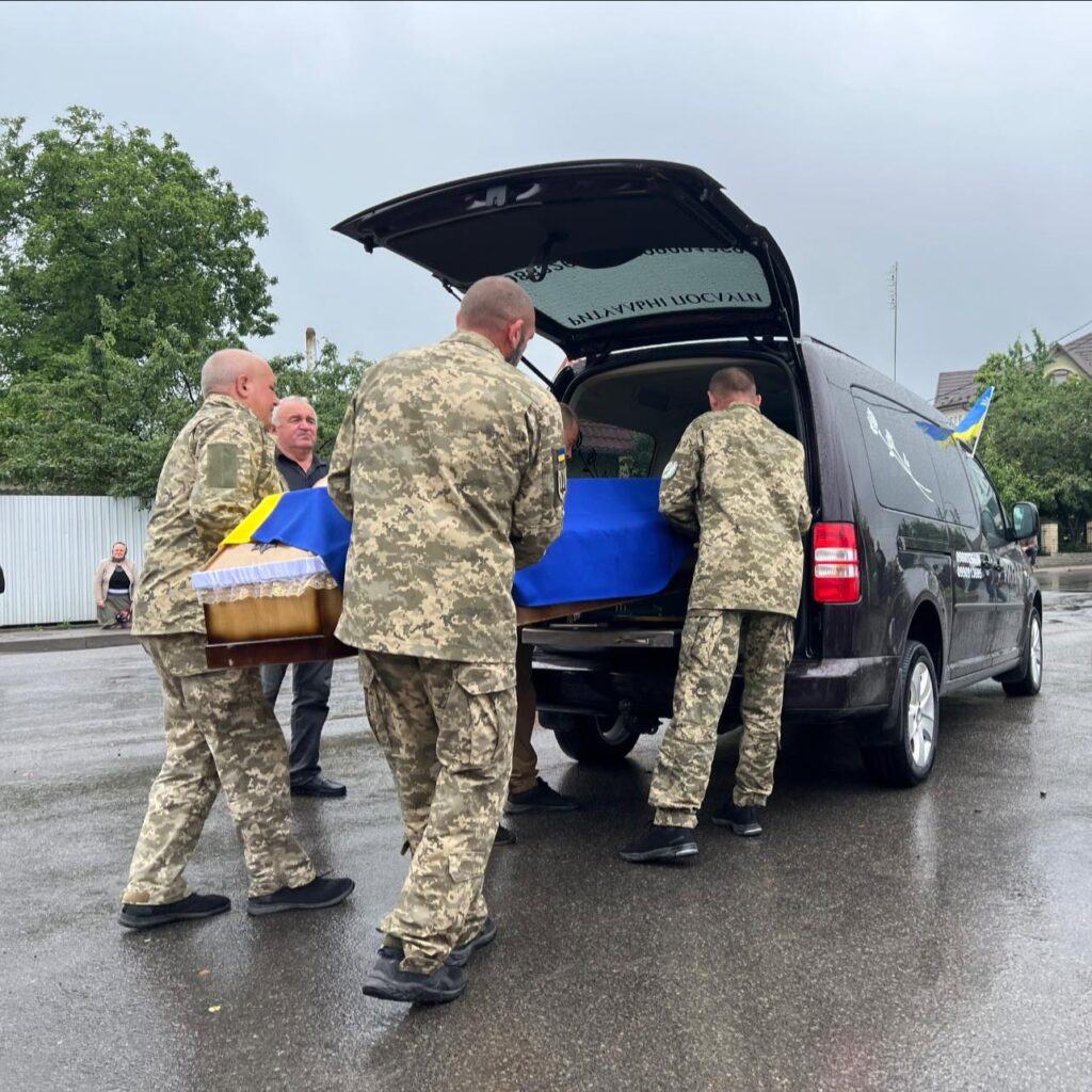 Військові несуть труну до автомобіля, похорон.