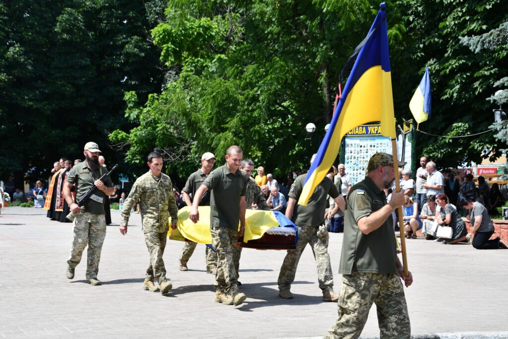 Військові несуть прапор України на церемонії похорону.