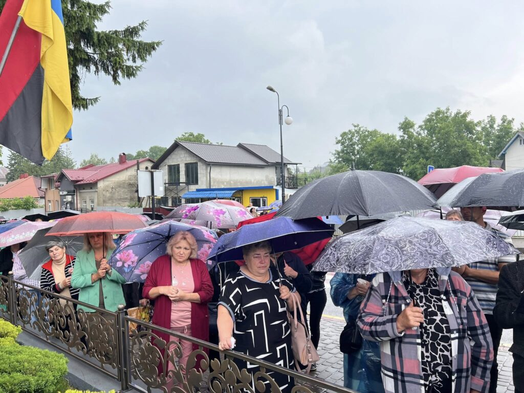 Люди під парасольками на вулиці під дощем.