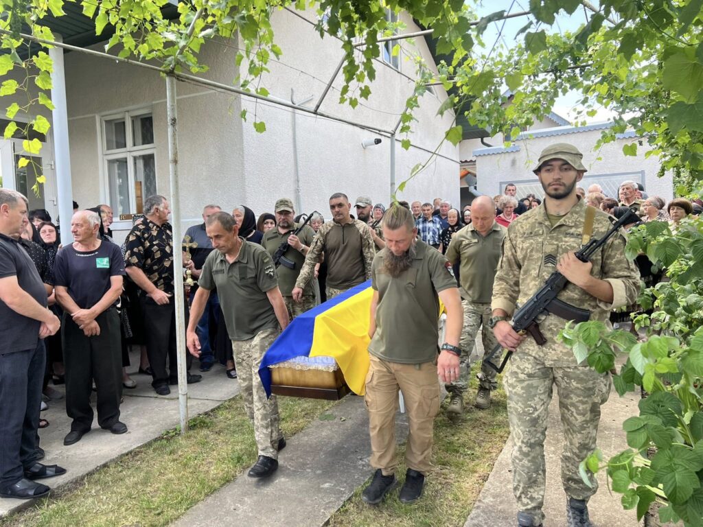 Похорон військового в Україні, люди несуть труну