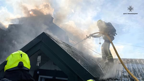 Пожежники борються з пожежею на будинку даху.
