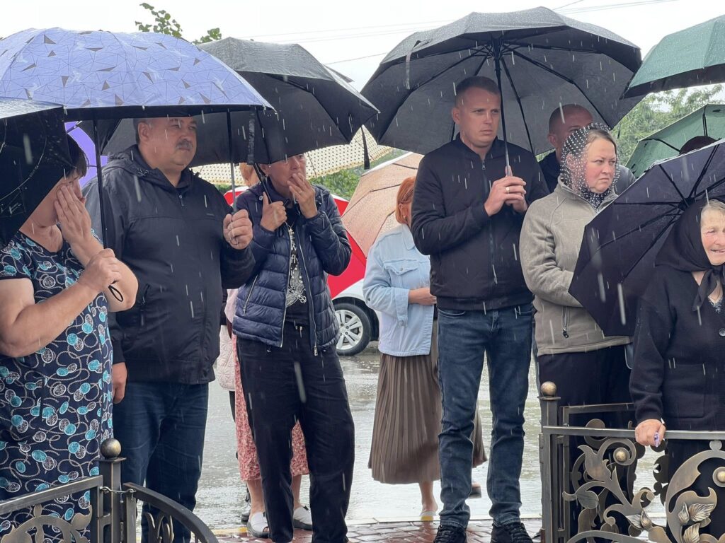 Група людей під парасольками під дощем
