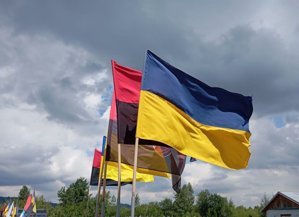 Український прапор розвівається на вітрі серед інших
