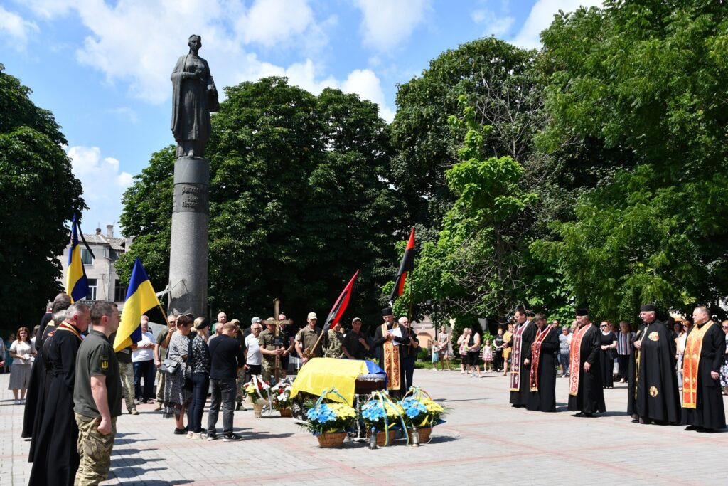 Церемонія біля пам’ятника з державними прапорами України.