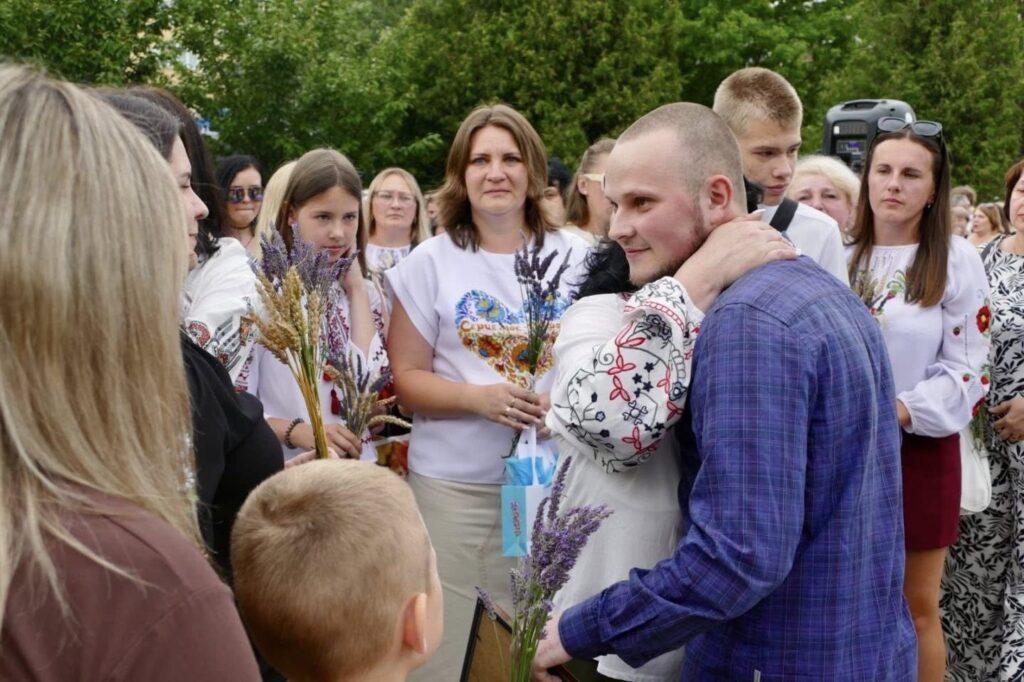 Зустріч з солдатом, обійми та квіти.