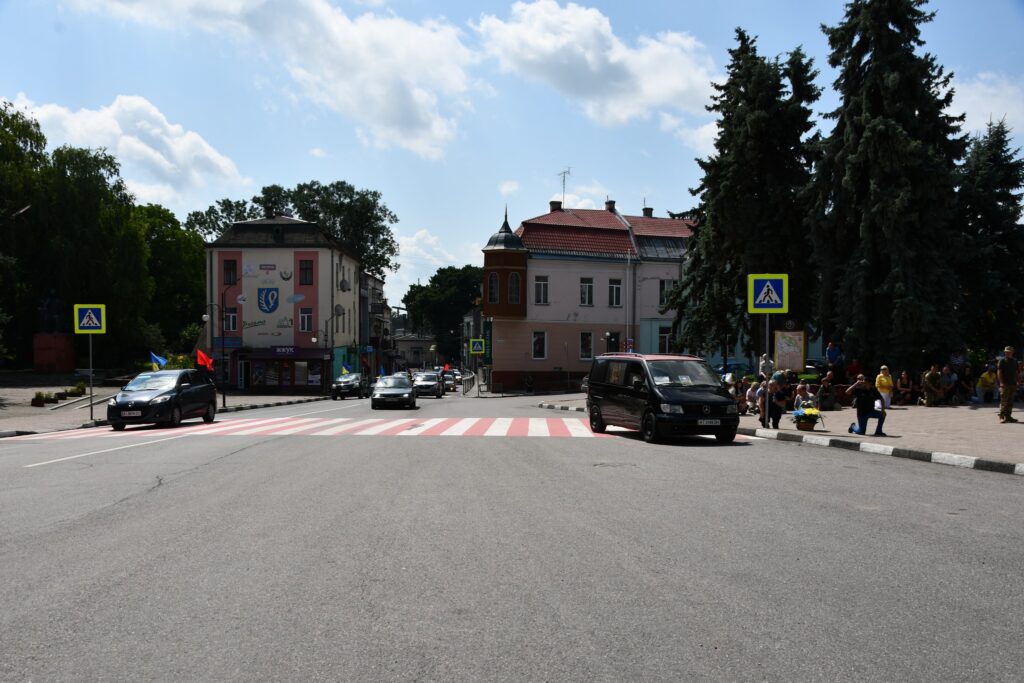 Вулиця з пішохідним переходом, автомобілі і пішоходи.
