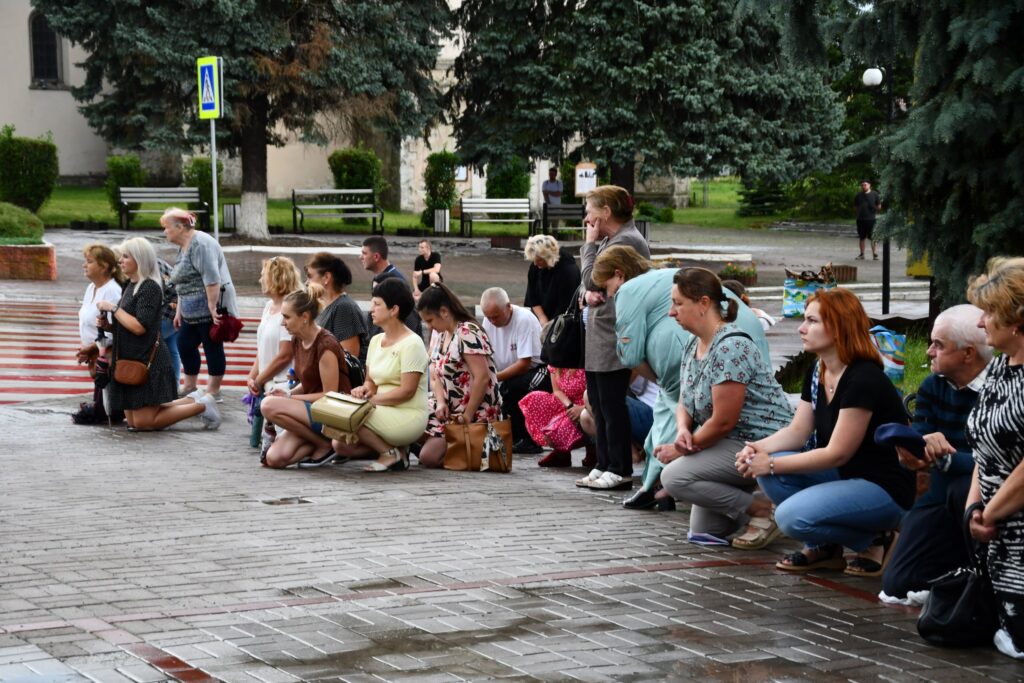 Люди стоять на колінах у парку