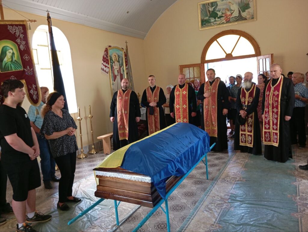 Похоронна служба в церкві, труна з прапором