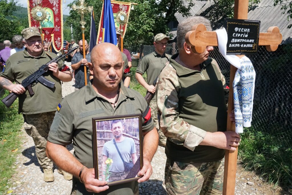 Українські військові на траурній церемонії з портретом.