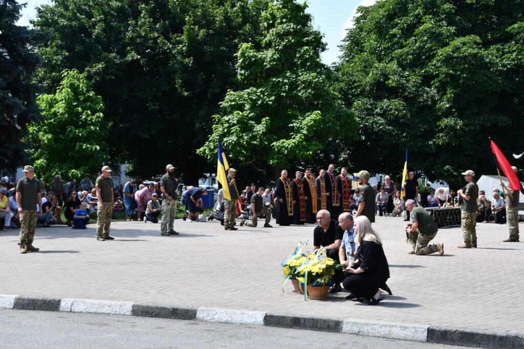 Поминальна церемонія з прапорами та військовими в Україні.
