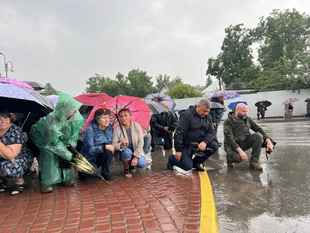 Люди під парасолями ховаються від дощу