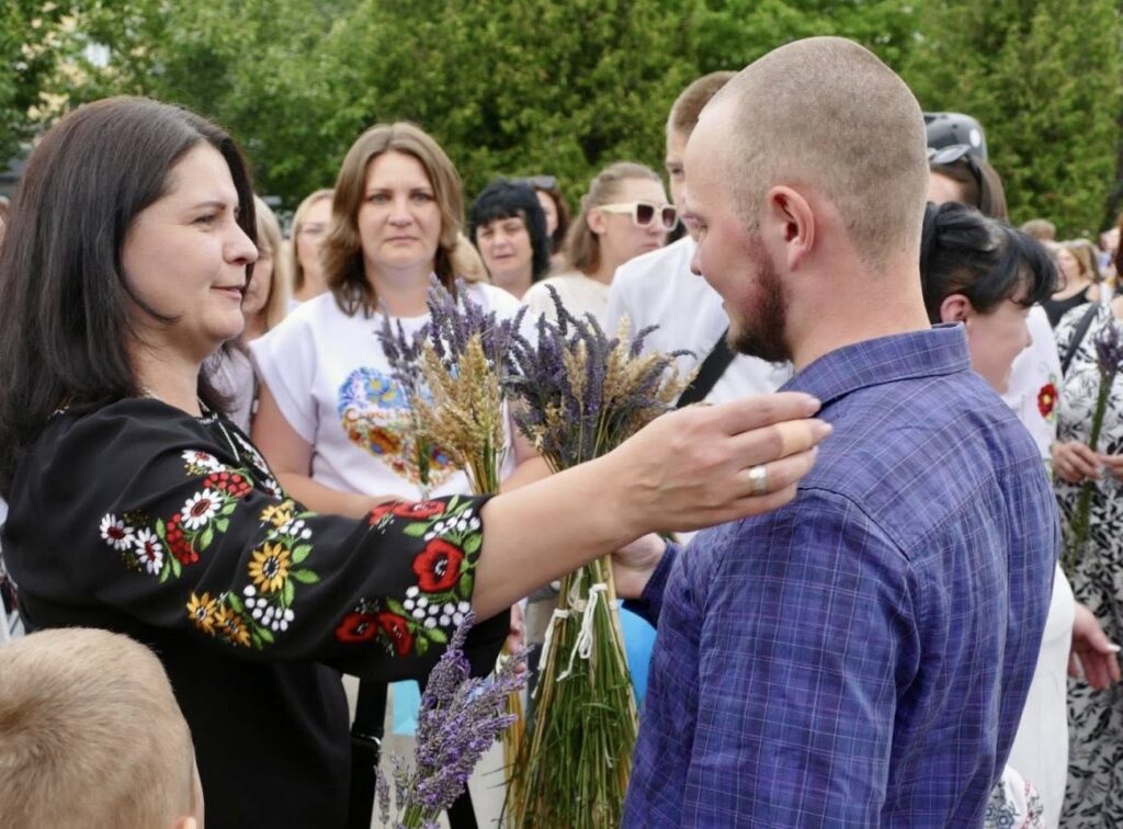 Жінка дарує букет чоловіку на святі