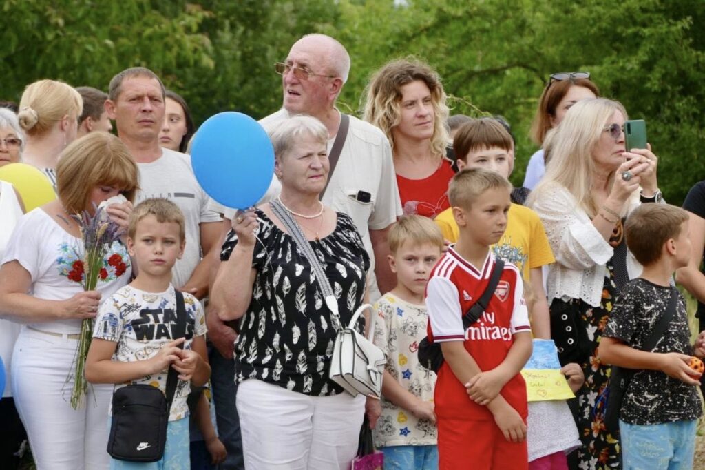 Група людей на відкритому повітрі серед дерев.