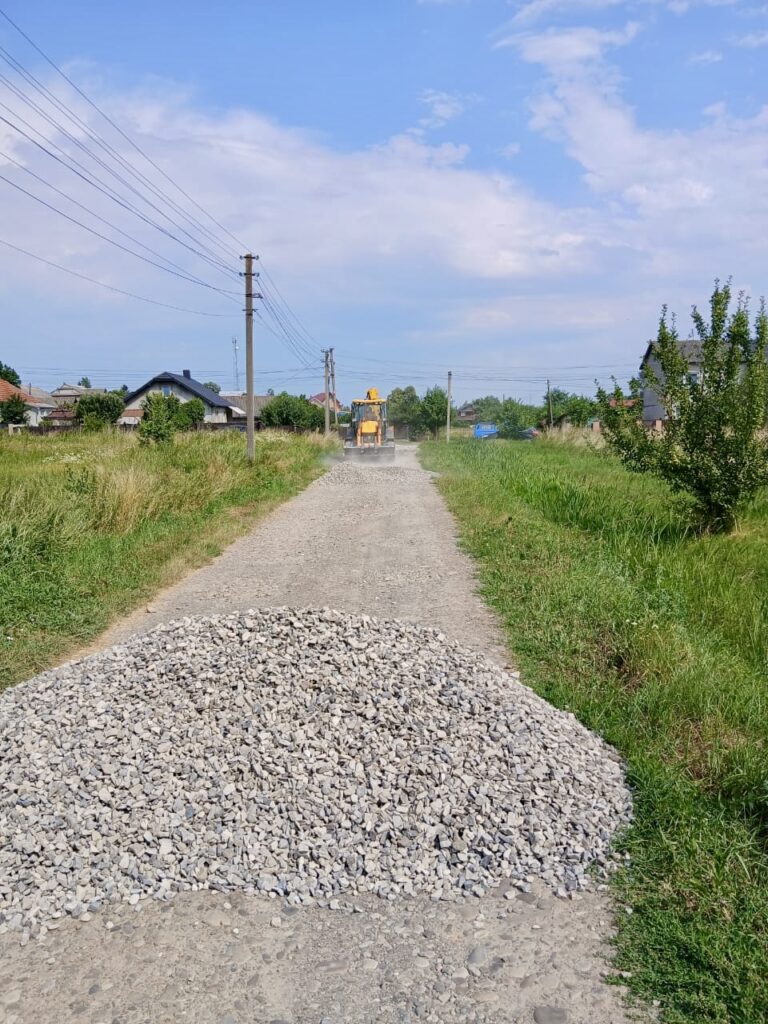 Гравій на дорозі у сільській місцевості з екскаватором.