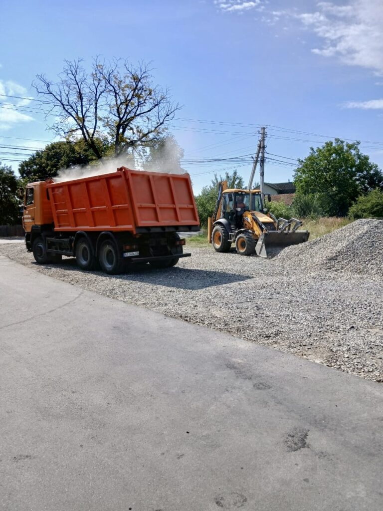 Вантажівка і екскаватор працюють на будівельному майданчику.