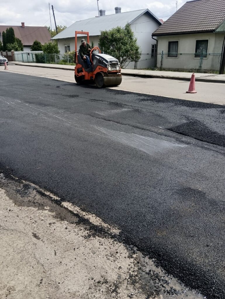 Дорожній каток на новій асфальтованій дорозі.