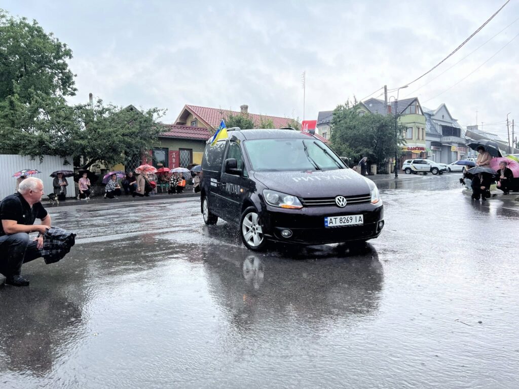 Чорний автомобіль під дощем на вулиці.