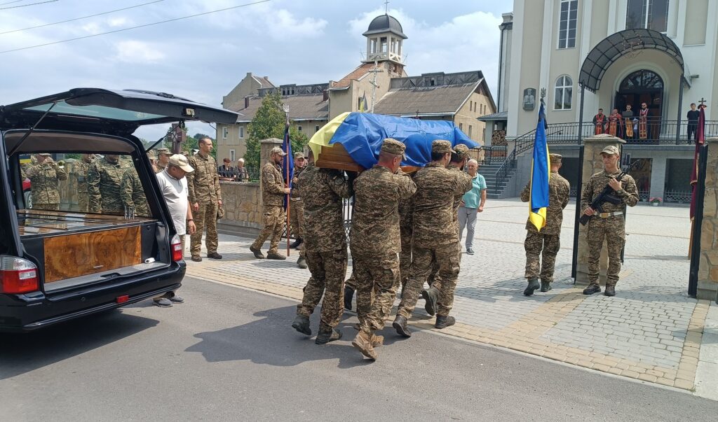 Військові несуть труну з українським прапором