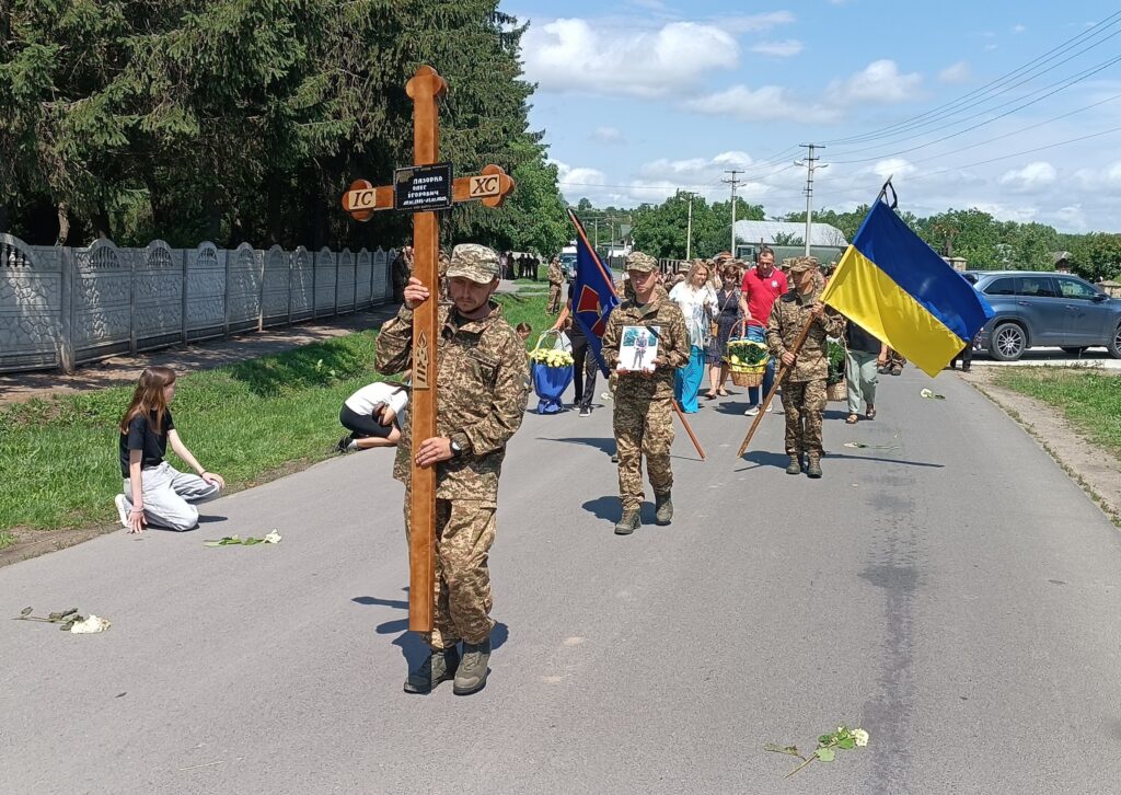 Військовий парад з українським прапором та хрестом.