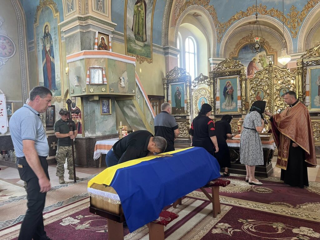 Похорон у церкві, труна з прапором України.