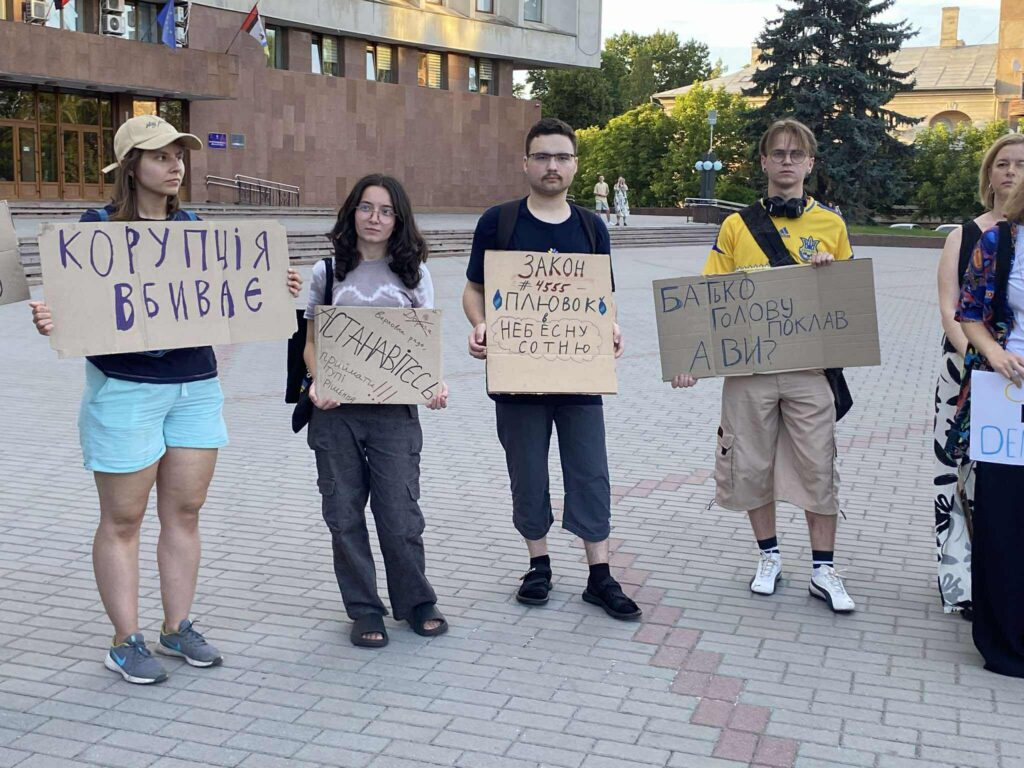Протестувальники тримають антикорупційні плакати у місті.