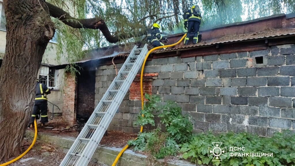 Пожежники гасять вогонь на даху будівлі.