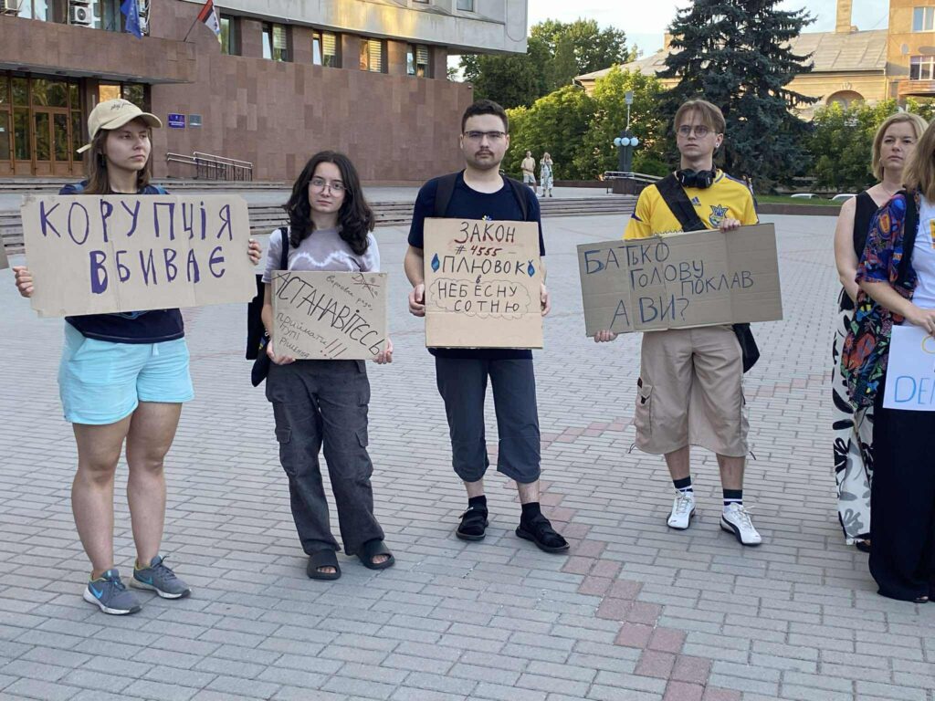 Протестувальники з плакатами проти корупції на площі.