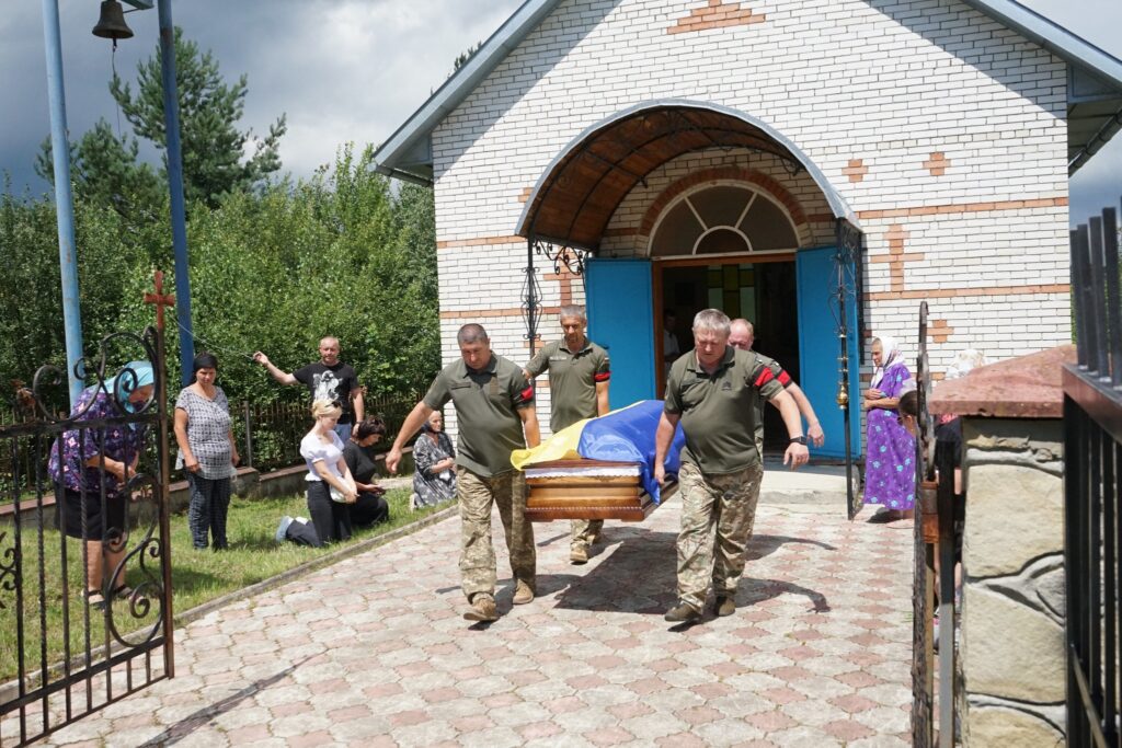 Військові несуть труну з прапором України