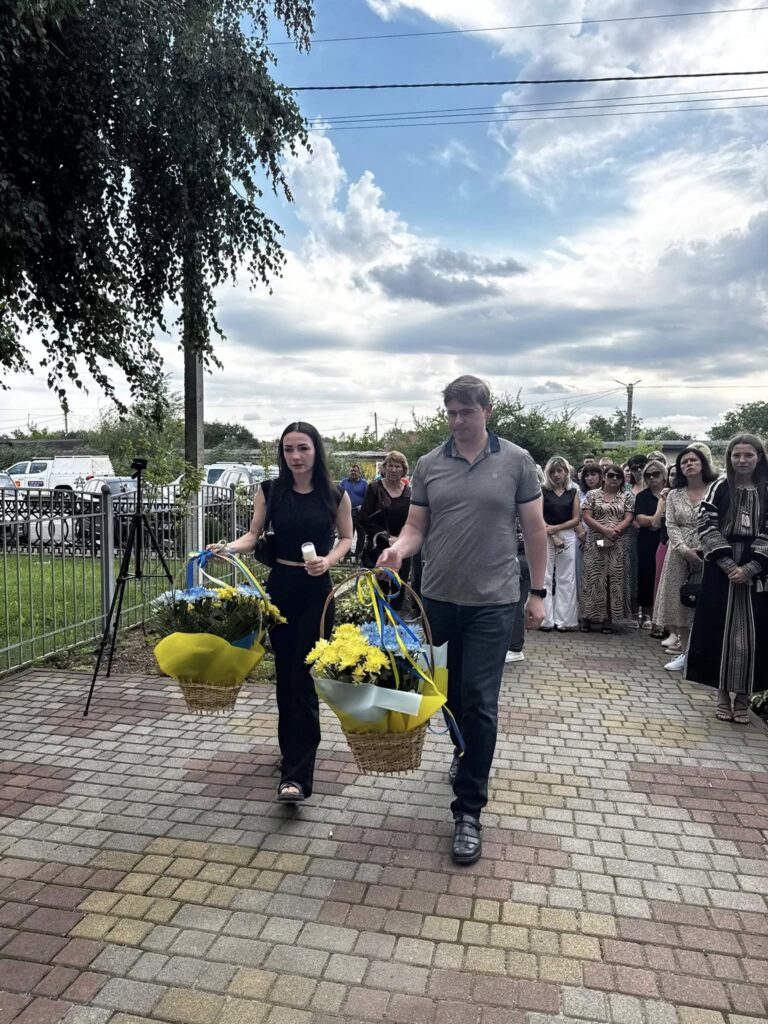 Люди несуть квіти на урочистій події