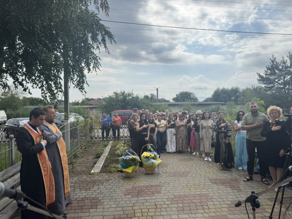 Церемонія зібрання людей на вулиці з квітами.