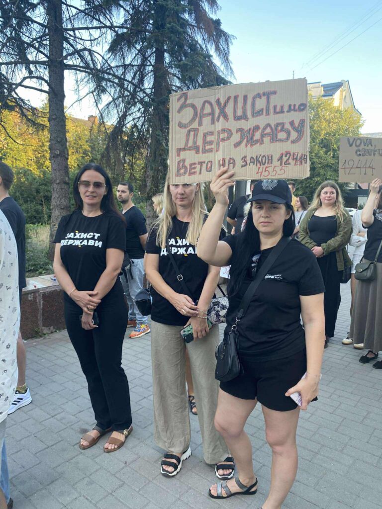 Люди протестують з плакатами за захист держави