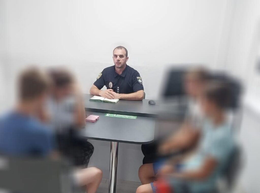 Поліцейський проводить бесіду в офісі з громадянами.