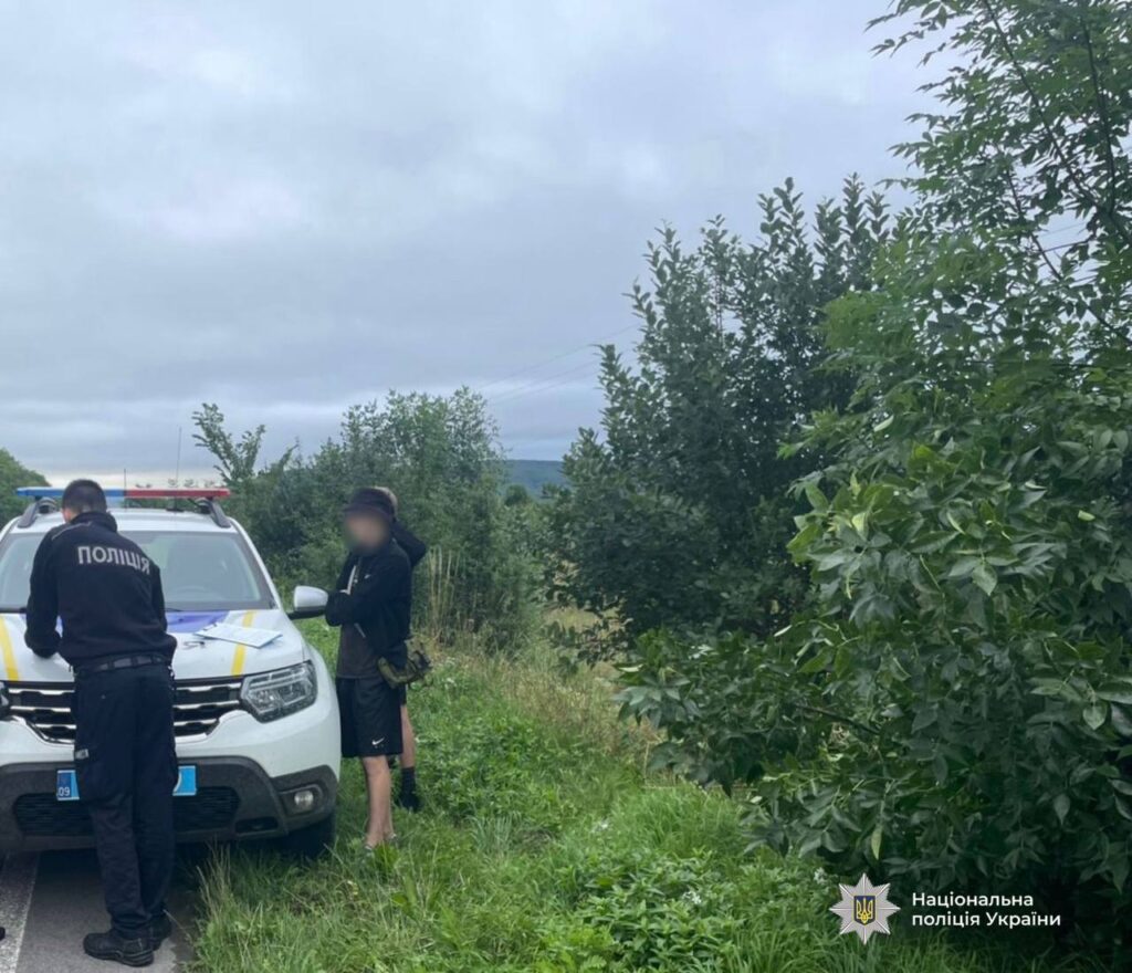 Поліція проводить перевірку на дорозі біля автівки.