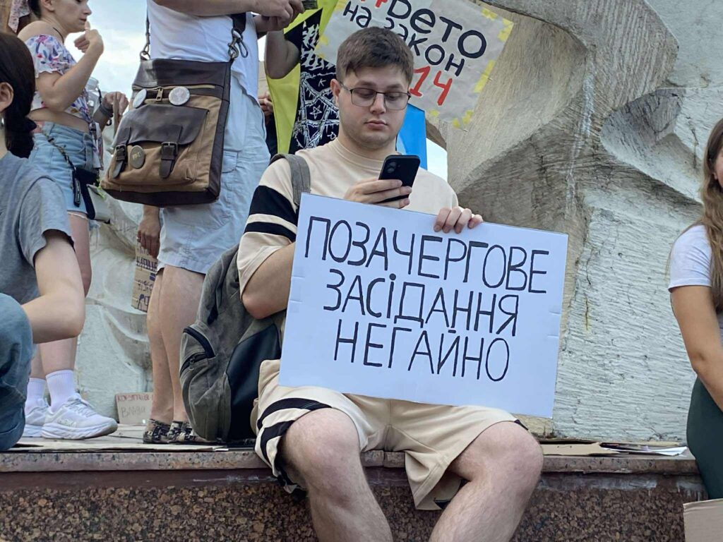 Людина з плакатом на протесті в Україні