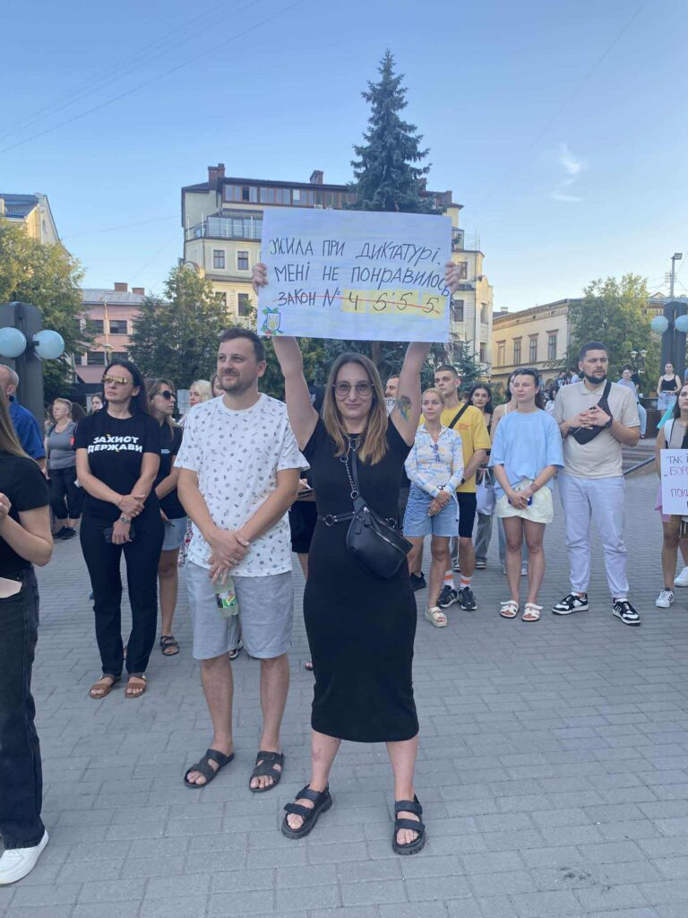Мітинг у місті, люди тримають плакати.