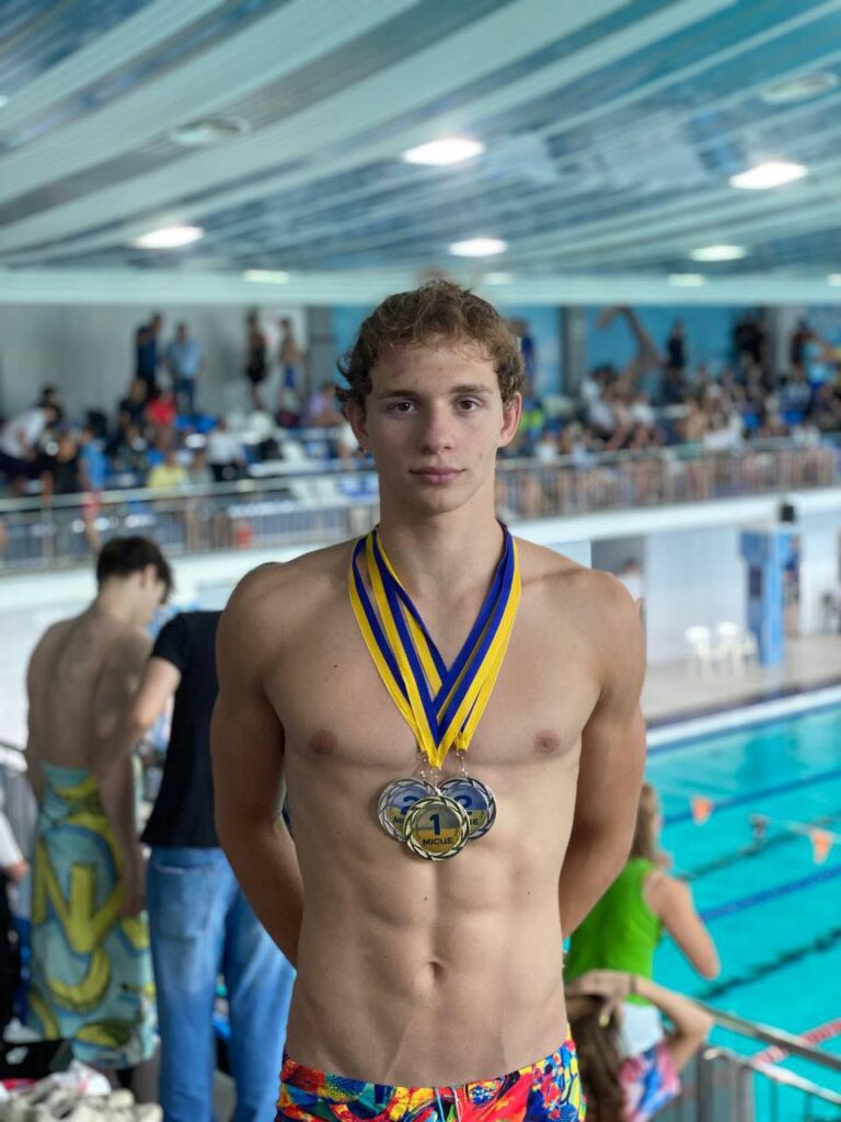 Чемпіон з плавання з медалями на шиї