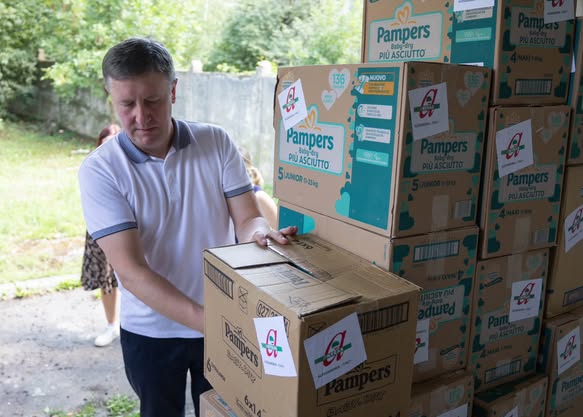 Чоловік розвантажує коробки з продукцією Pampers