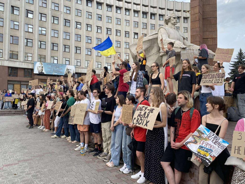 Протестна акція на вулиці, люди тримають плакати.