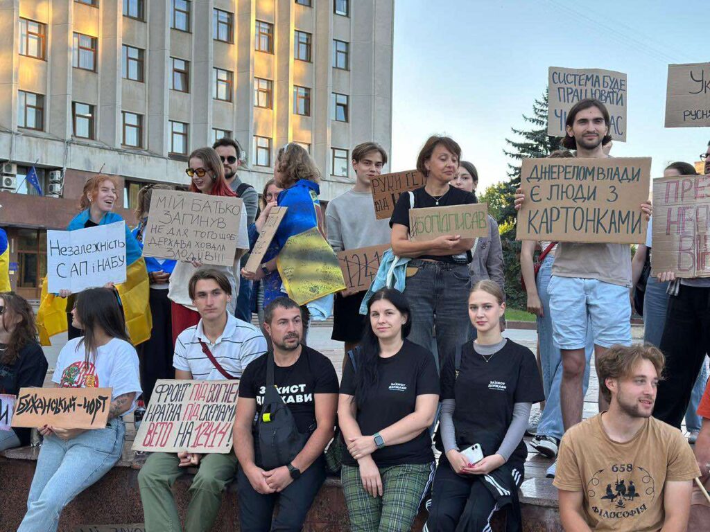 Протестуючі з плакатами на вулиці.