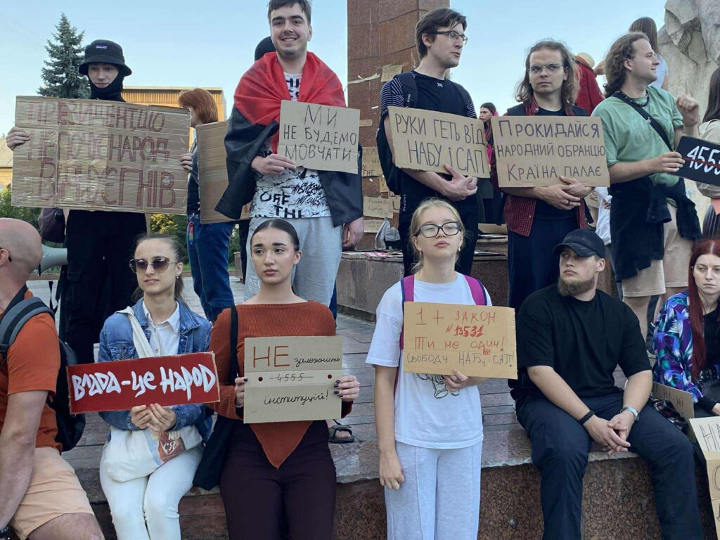 Люди на протесті, тримають плакати з вимогами.