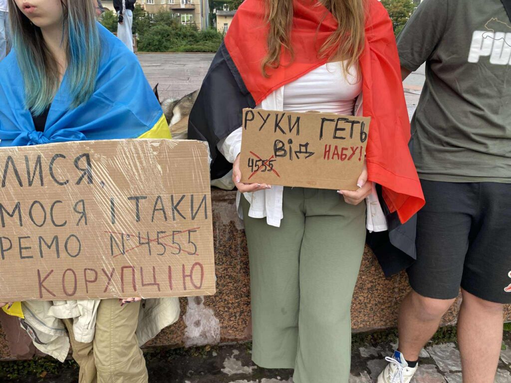 Протест з плакатами та прапорами в руках.