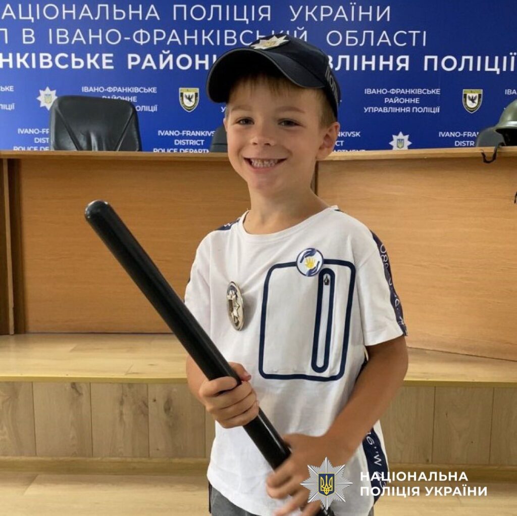 Дитина у формі поліції з посмішкою