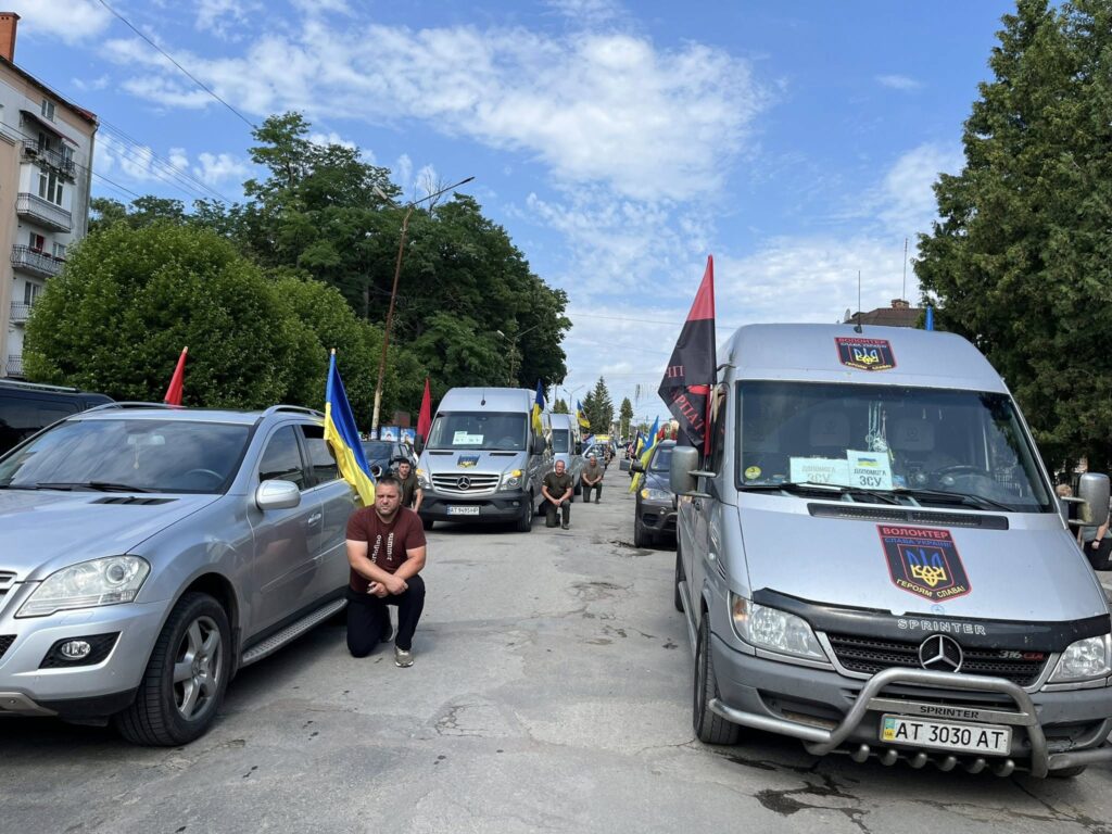 Автомобілі з прапорами на вулиці міста