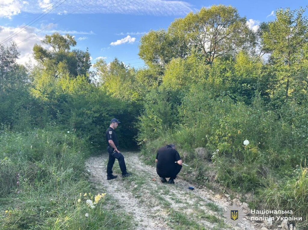 Поліцейські оглядають лісову стежку під час розслідування.