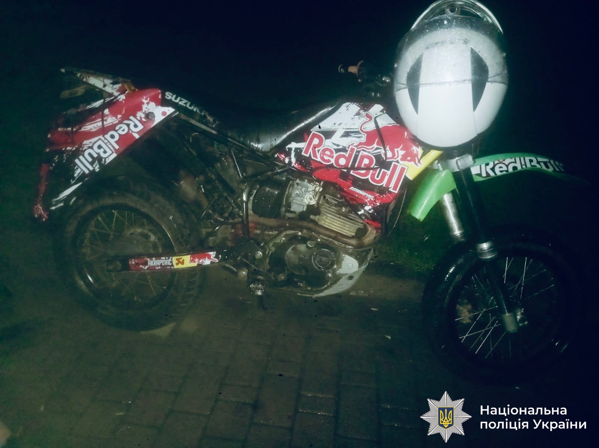 Мотоцикл з логотипом Red Bull вночі.