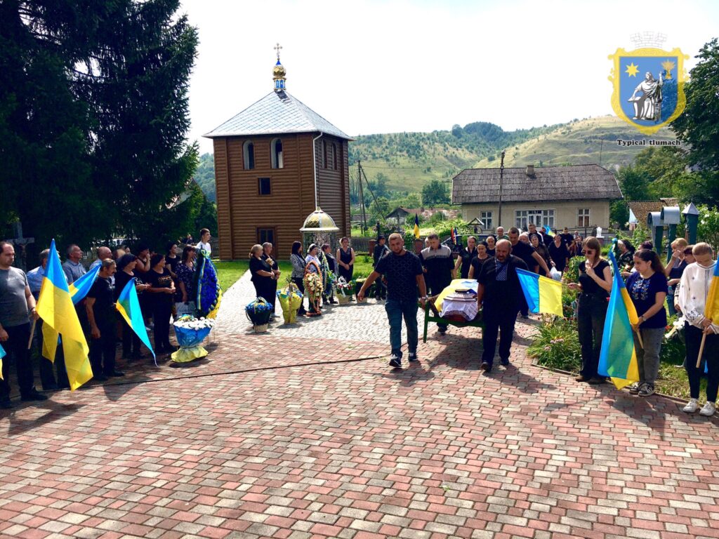 Люди з прапорами на поминальному заході