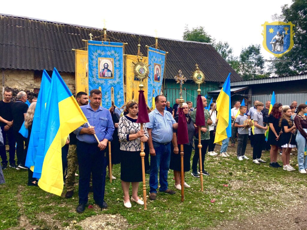 Люди з прапорами України на релігійному заході.