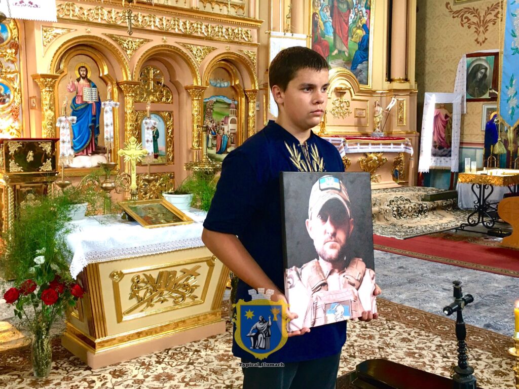 Хлопець тримає портрет у церкві