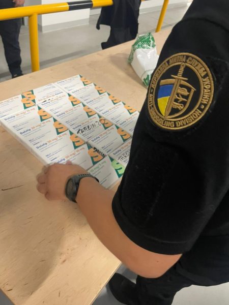 Працівник митниці перевіряє документи на столі.