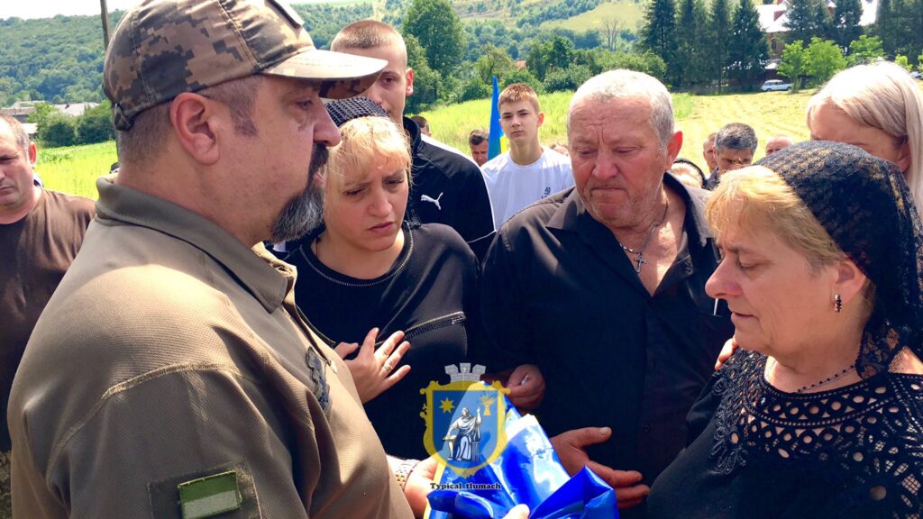 Церемонія з українським прапором на відкритому повітрі.